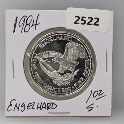 Sale Photo Thumbnail #1013: 1984 Engelhard 1 troy ounce .999 fine silver round featuring an American eagle design, housed in a protective coin flip holder.