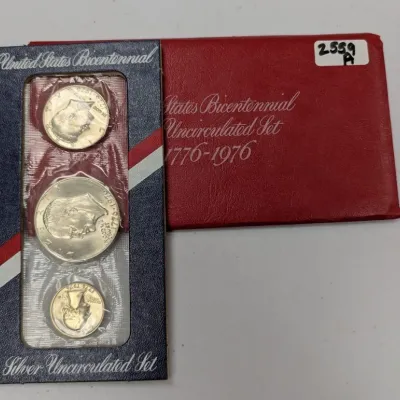 Sale Photo Thumbnail #1051: 1976 United States Bicentennial 3-piece silver uncirculated coin set, including a Eisenhower dollar, Kennedy half dollar, and Washington quarter in original US Mint packaging with red envelope.