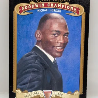 Sale Photo Thumbnail #842: Upper Deck Presents Goodwin Champions Michael Jordan trading card, featuring a painted portrait of Jordan in a suit against a blue backdrop.