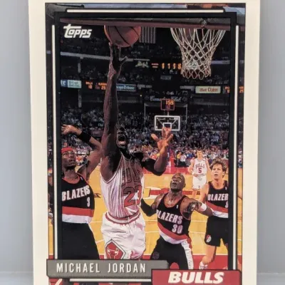 Sale Photo Thumbnail #503: 1992-93 Topps Michael Jordan #115 basketball card, featuring an action shot of Jordan driving against the Portland Trail Blazers.
