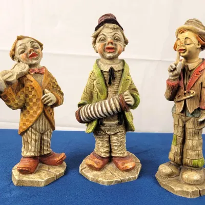 Set of three vintage figurines featuring a violinist, an accordion player, and a thinker.
