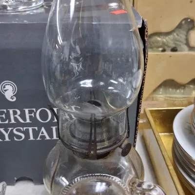 Vintage clear pressed glass kerosene oil lamp featuring a side handle and clear glass hurricane shade, shown in good overall condition.