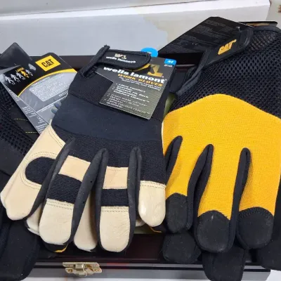 Assortment of new-with-tags work gloves, including Caterpillar brand and Wells Lamont, in size large.