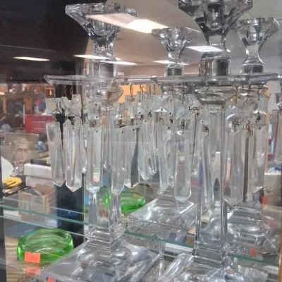 Pair of vintage crystal candlestick holders with hanging prism drops, displayed in a glass showcase.