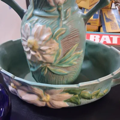 Roseville Pottery Water Lily double-handled vase sitting in a matching console bowl, featuring a matte green glaze with relief floral...