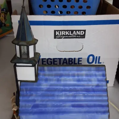 Stained glass illuminated church lamp with a blue roof, white panels, and attached power cord.