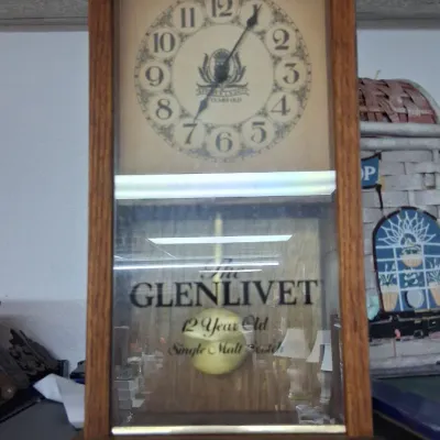 Vintage The Glenlivet promotional wooden regulator wall clock featuring a pendulum and printed glass front.