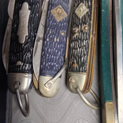 Collection of vintage pocket knives, including a Kamp-King folding utility knife and official Cub Scouts BSA multi-blade knives, showing...