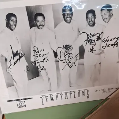 Autographed black-and-white promotional photo of Motown group The Temptations, signed in black marker by member line-up including Ron...
