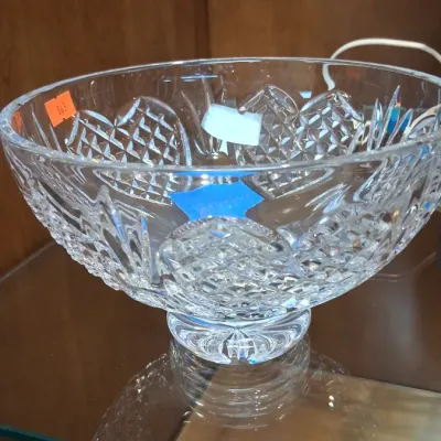 Large Waterford pedestal bowl with intricate diamond and fan motifs, displayed inside a glass cabinet.
