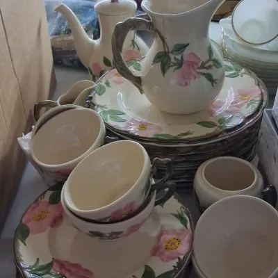 Franciscan Desert Rose pattern dinnerware set featuring a pitcher, teapot, teacups, saucers, and plates.