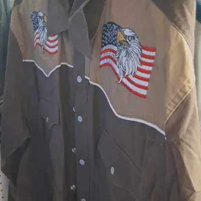Vintage-style Western snap-button shirt featuring two-tone brown and tan paneling with embroidered bald eagle and American flag chest...
