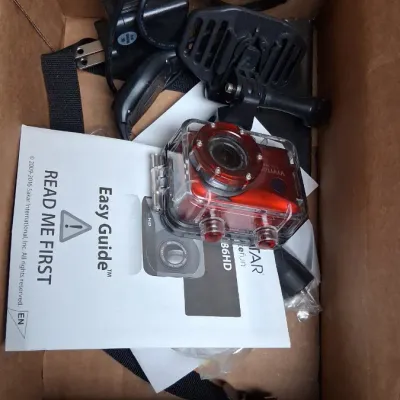 Vivitar DVR 786HD action camera kit inside a cardboard box, complete with waterproof housing, mounting accessories, cables, and user manual.