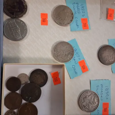 Collection of US silver dollars and assorted coins, including a 1922-S Peace dollar and 1890 Morgan dollars, presented in a felt display...