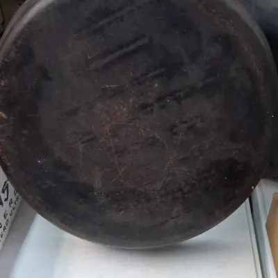 Vintage cast iron pan showing heavily seasoned, dark patina and light surface wear on the underside.