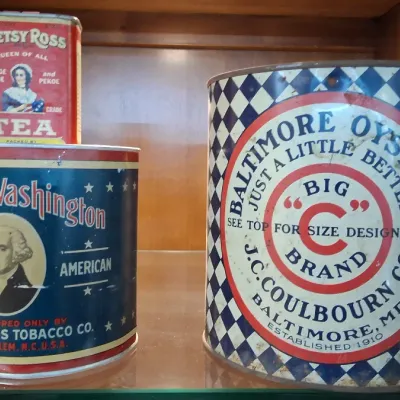 Trio of vintage advertising tins, including Betsy Ross Tea, George Washington Tobacco, and a large Baltimore Oysters tin.