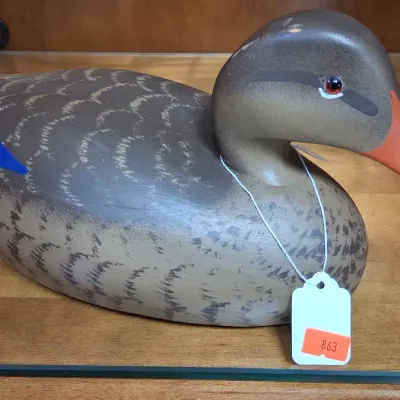 Hand-painted wooden duck decoy featuring detailed feather work, a red bill, and glass eyes.