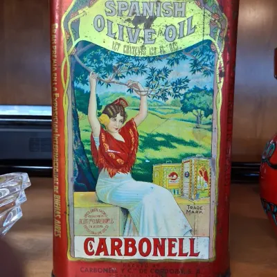 Vintage Carbonell Spanish Olive Oil tin container with colorful illustrated graphic of a woman in traditional attire, showing...