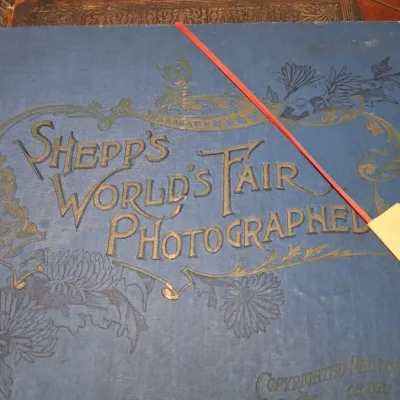 Antique copy of 'Shepp's World's Fair Photographed' book featuring embossed blue cloth cover with ornate gold...