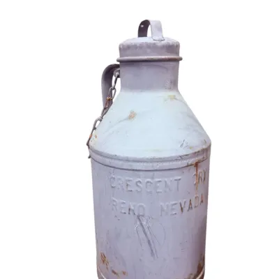 Sale Photo Thumbnail #17: Vintage metal milk can with lid and side handle, embossed with "Crescent Creamery Reno Nevada" and showing rustic patina.
