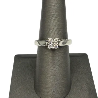 Sale Photo Thumbnail #75: White gold ring featuring a cluster of four round accent stones in a square setting, presented on a jewelry display cone.