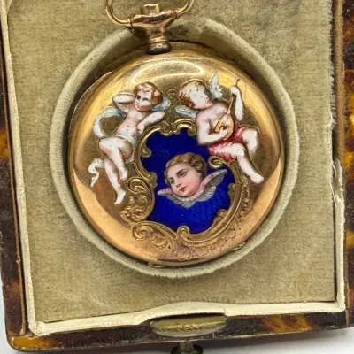 Sale Photo Thumbnail #69: Antique gold pocket watch featuring a polychrome enamel case decorated with cherubs and cobalt blue guilloché, resting in a velvet-lined fitted box.