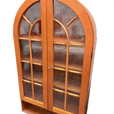 Sale Photo Thumbnail #31: Arched oak curio cabinet with double glass paneled doors, interior shelving, and a bottom open display shelf.