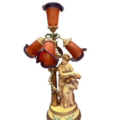 Sale Photo Thumbnail #16: Art Nouveau figural table lamp featuring a seated woman holding a book, supporting four orange and purple lily-form glass shades.