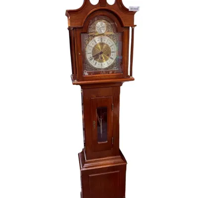 Sale Photo Thumbnail #41: Traditional wooden grandfather clock by Daneker, featuring a swan-neck pediment with finial, ornate brass dial, and a visible pendulum window.