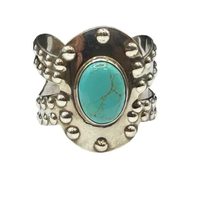 Sale Photo Thumbnail #79: Native American style sterling silver cuff bracelet featuring a central oval turquoise cabochon with matrix, accented by beaded silver trim.