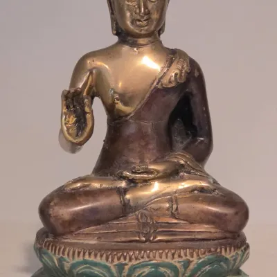 Sale Photo Thumbnail #12: Seated brass Buddha statue with green patina accents on a lotus base, displaying the Abhaya mudra gesture.