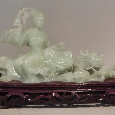 Sale Photo Thumbnail #13: Hand-carved pale green jade sculpture depicting a female figure riding a dragon, mounted on a custom dark wood base.