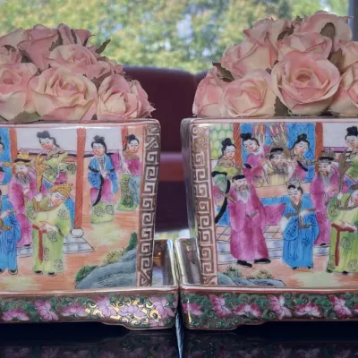 Sale Photo Thumbnail #28: Pair of Chinese Famille Rose square porcelain planters with matching underplates, featuring hand-painted figurative court scenes and pink faux rose arrangements.