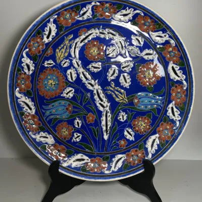 Sale Photo Thumbnail #36: Hand-painted Turkish Iznik-style decorative ceramic plate featuring vibrant blue glaze, floral motifs, and raised enamel accents.