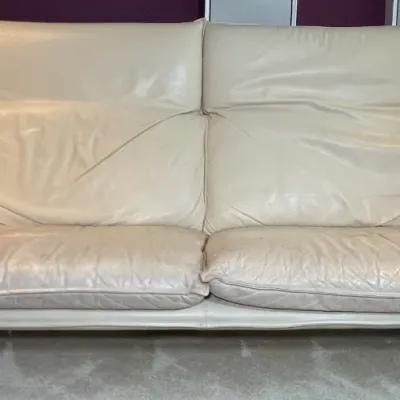 Sale Photo Thumbnail #79: Modern off-white leather high-back sofa featuring overstuffed cushion seating and pillow armrests.