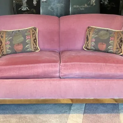 Sale Photo Thumbnail #75: Vintage Art Deco style pink velvet loveseat with polished brass trim and two decorative accent pillows.
