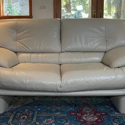 Sale Photo Thumbnail #2: Contemporary light gray leather loveseat featuring thick padded cushions and low-profile upholstered block feet.