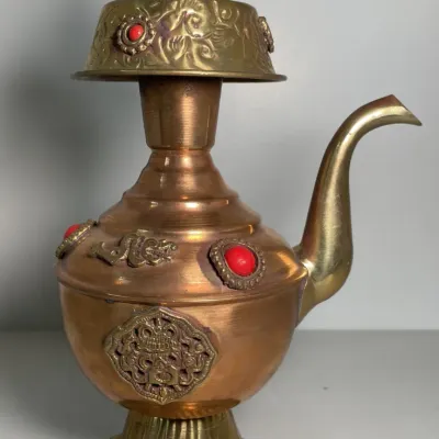 Sale Photo Thumbnail #35: Ornate Tibetan-style copper and brass teapots adorned with red cabochon beads and embossed dragon detailing.