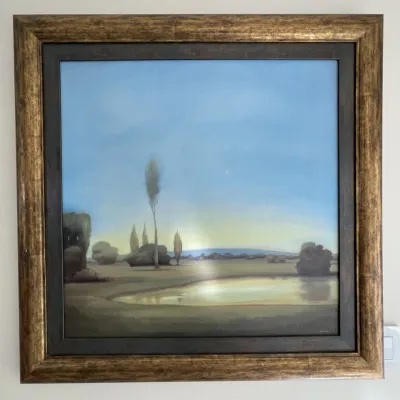 Sale Photo Thumbnail #45: Framed tonalist landscape painting depicting a serene field with a pond and cypress trees under a soft sky, set in a wide gilded frame.