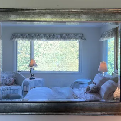 Sale Photo Thumbnail #7: Large wall mirror with a beveled glass edge and a distressed silver-finish frame.