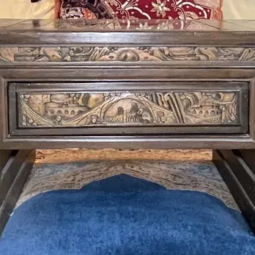 Sale Photo Thumbnail #81: Ornately carved dark wood coffee table featuring intricate relief scenes on drawer fronts and aprons.