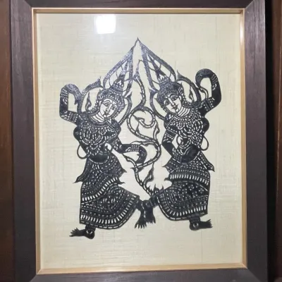 Sale Photo Thumbnail #47: Framed vintage Thai shadow puppet artwork depicting traditional dancers mounted on a woven fabric background.