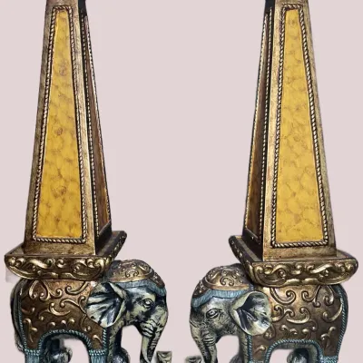 Sale Photo Thumbnail #27: Pair of ornate composite decorative obelisks featuring intricately detailed elephant bases with gold-toned and faux-stone finishes.