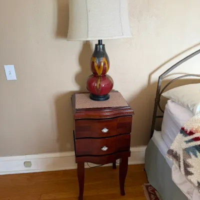 Sale Photo Thumbnail #139: Two-drawer mahogany nightstand with cabriole legs, topped with a glazed ceramic double-gourd table lamp.