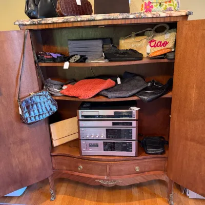 Sale Photo Thumbnail #164: Vintage French Provincial style wooden cabinet with marble top filled with various women's handbags, clutches, accessories, and a vintage stereo system stack.