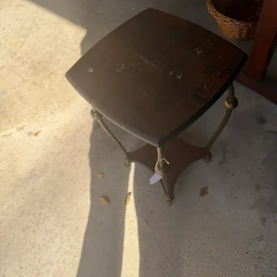Sale Photo Thumbnail #222: Vintage dark wood side table featuring brass legs and a lower tier shelf. The wood top shows visible wear and surface distress.