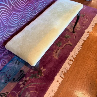 Sale Photo Thumbnail #91: Long, traditional bench upholstered in pale yellow velvet with carved dark wood cabriole legs, shown sitting on a purple floral rug.
