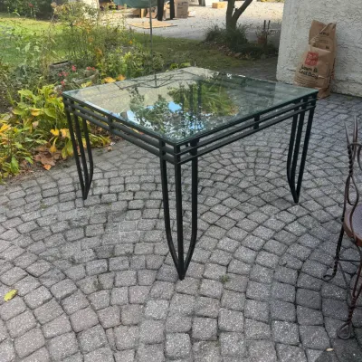 Sale Photo Thumbnail #195: Square wrought iron patio dining table with a clear glass top, featuring tapered curved legs.