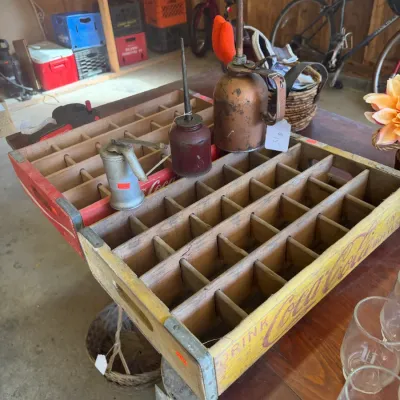 Sale Photo Thumbnail #213: Vintage wooden Coca-Cola bottle crates displaying a collection of antique metal oil cans.
