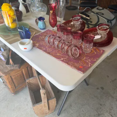 Sale Photo Thumbnail #207: Collection of vintage glassware, including ruby-stained glass tumbler sets, dessert plates, teacups, clear art glass vases, and decorative table linens.